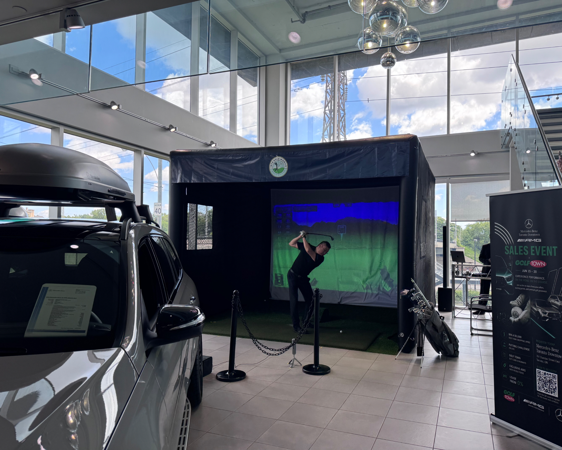 Guest swinging inside the 19th Hole Mobile simulator at a Mercedes-Benz Toronto dealership event